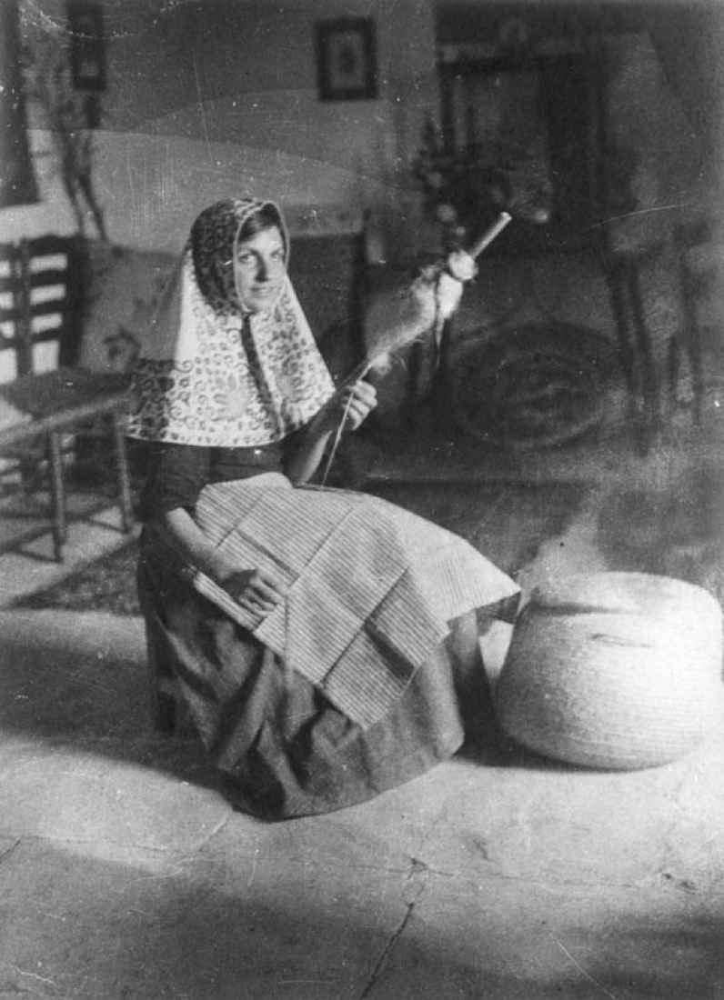Noia amb mocador tradicional filant a Sa Llopassa